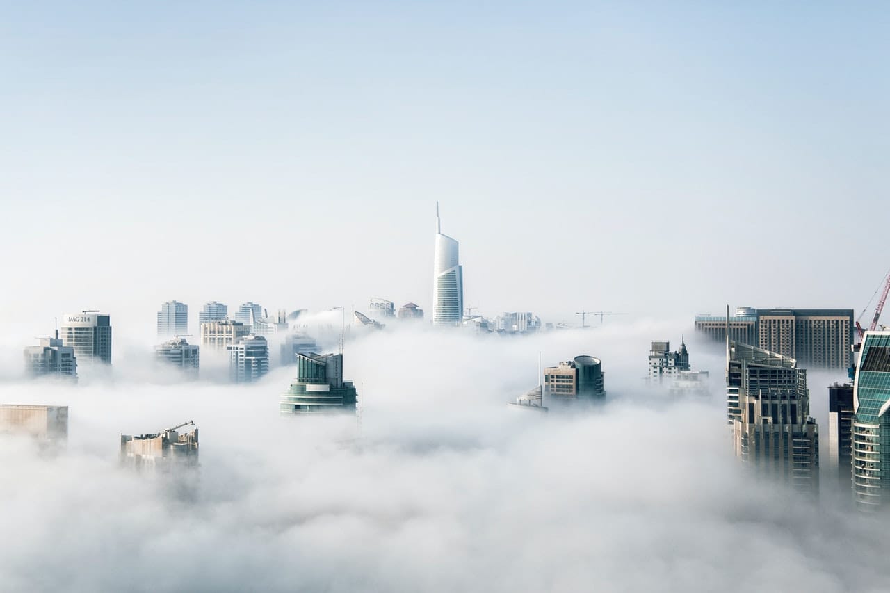 The tops of high-rises crest over the cloud layer